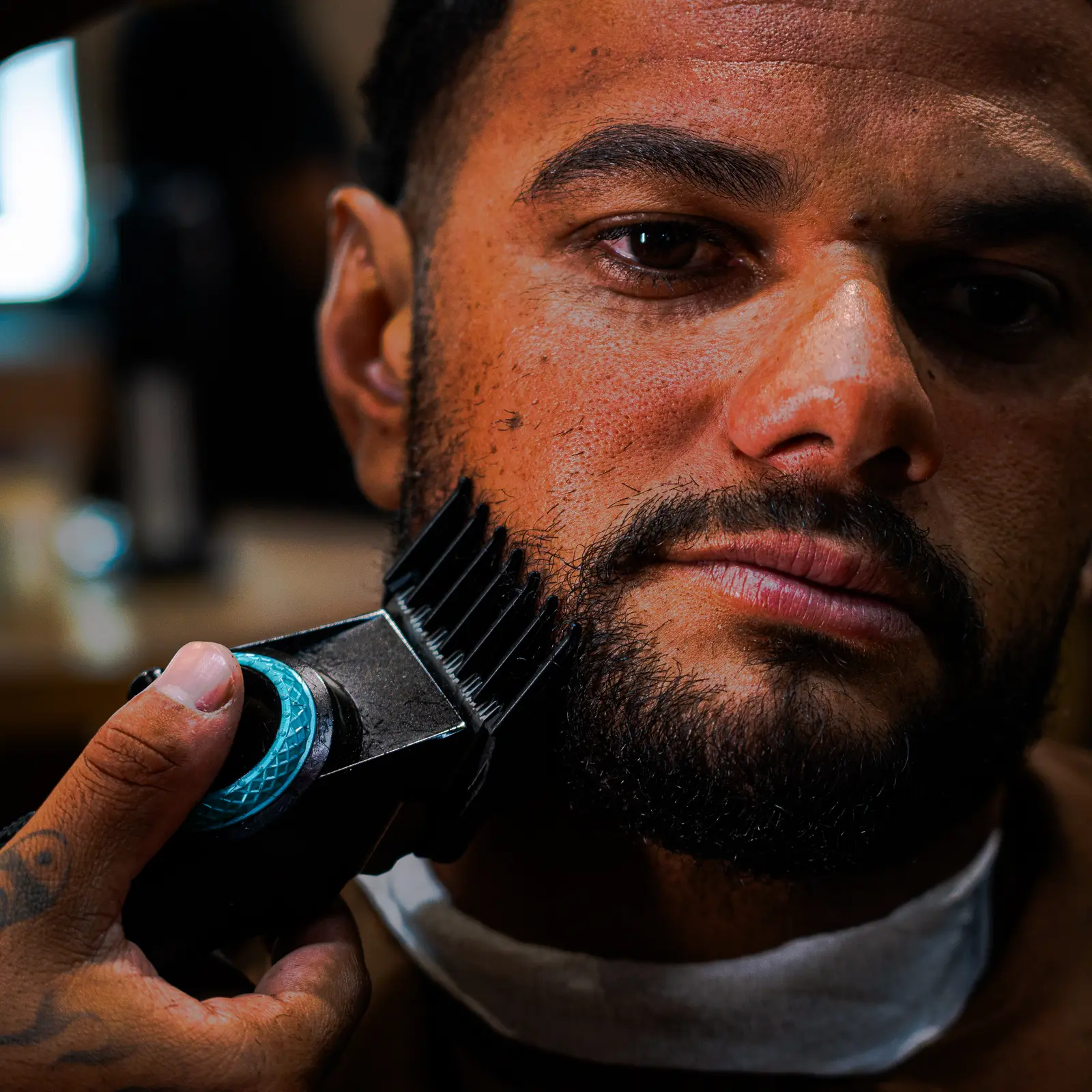 Cliente da Cleto com a barba sendo acertada na máquina
