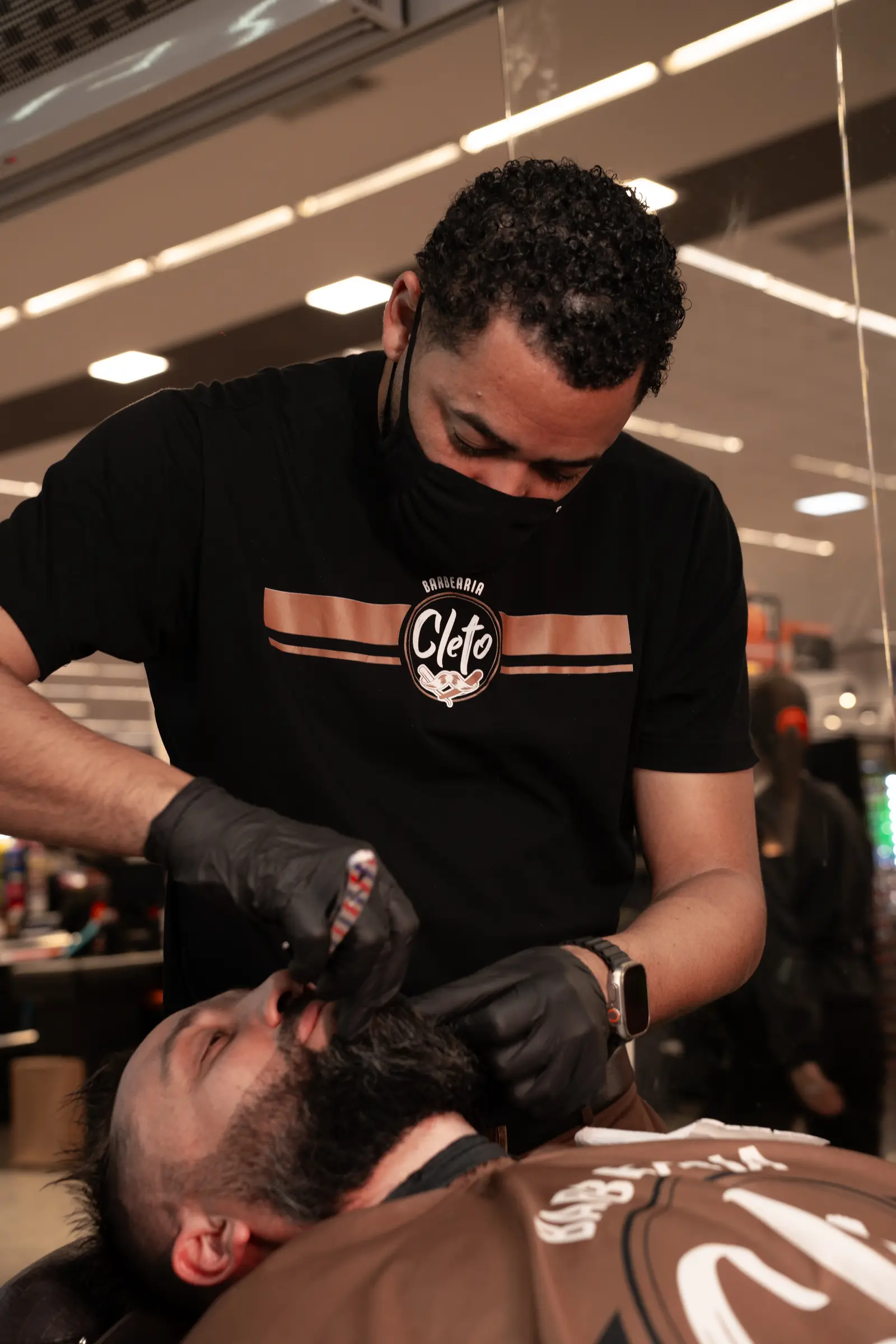 Barbeiro da Cleto fazendo a barba de um cliente na navalha